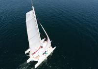 mast top with flatten main sail on multihull trimaran yacht sailing